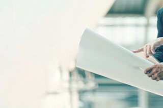 Drei Personen die sich einen Plan anschauen