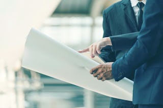 Drei Personen die sich einen Plan anschauen