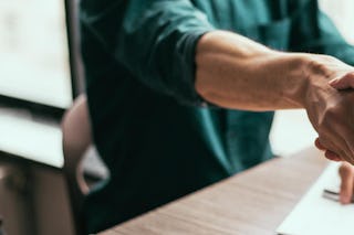 Zwei Personen beim Handshake, nach der Unterzeichnung eines Dokuments