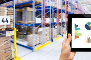 Person mit Tablett vor Palettenregal