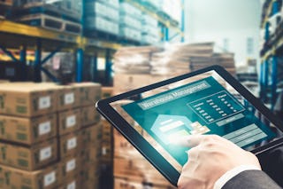 Eine Person die über ein Tablett die Lagerbestände überwacht