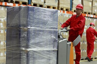 Zwei Arbeiter in einem Lager. Einer bewegt eine optimal verpackte Palette.