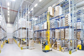 Drei Arbeiter in einem Lager mit Palettenregalen