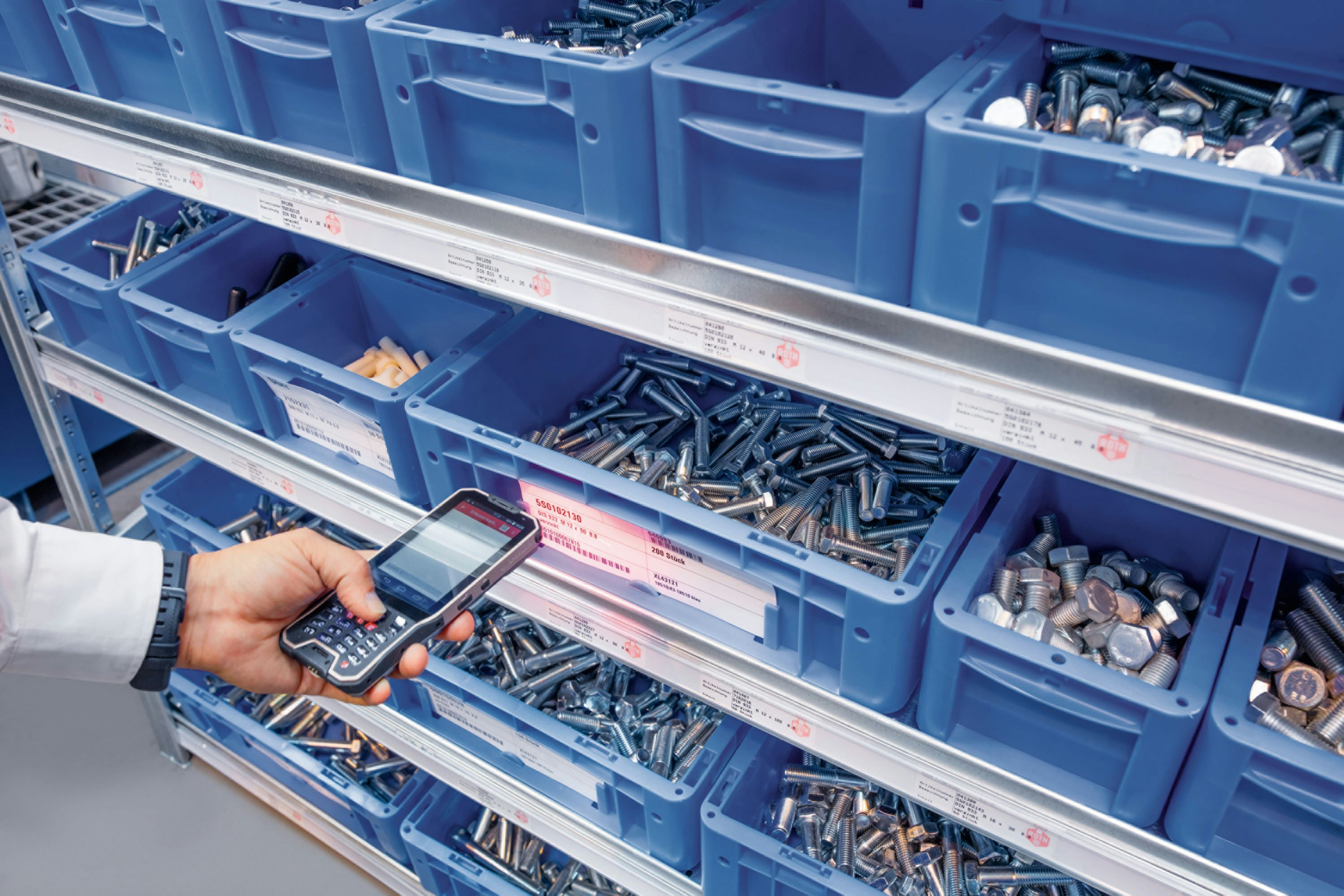 Eine Person die mit Hilfe eines Handscanners einen Behälter Scannt