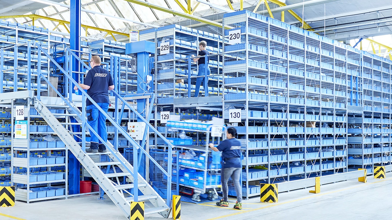 Mehrere Arbeiter in einem Lager mit Euromodulbehältern von BITO