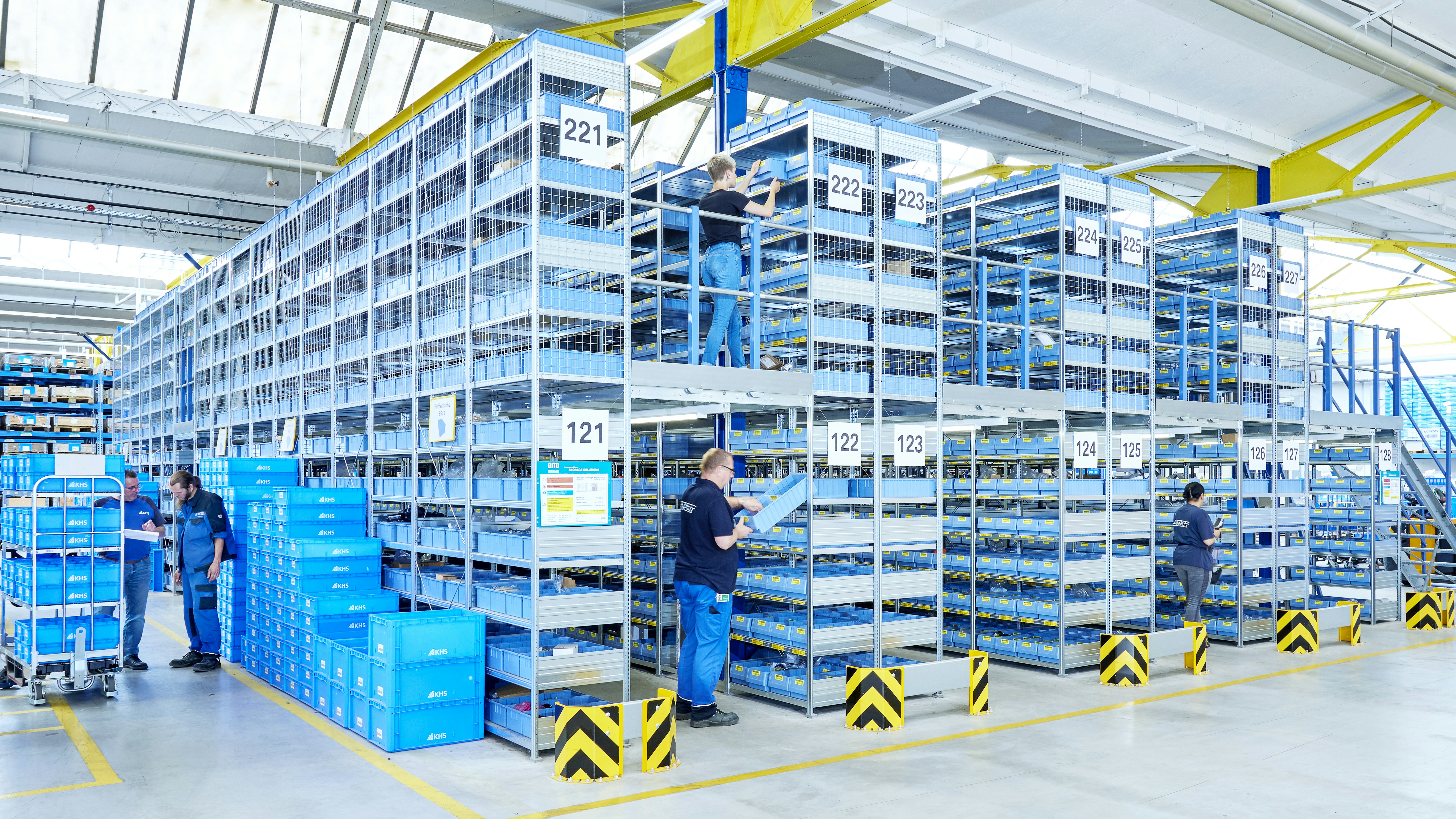 Mehrere Arbeiter in einem Lager mit Euromodulbehältern von BITO