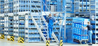 Mehrere Arbeiter in einem Lager mit Euromodulbehältern von BITO