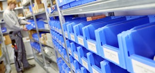 Ein Arbeiter entnimmt Ware aus einem Kleinteilelager