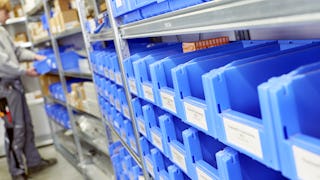 Ein Arbeiter entnimmt Ware aus einem Kleinteilelager