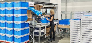 Eine Frau bei ihrer Arbeit, um sie herum stehen Klappboxen EQ