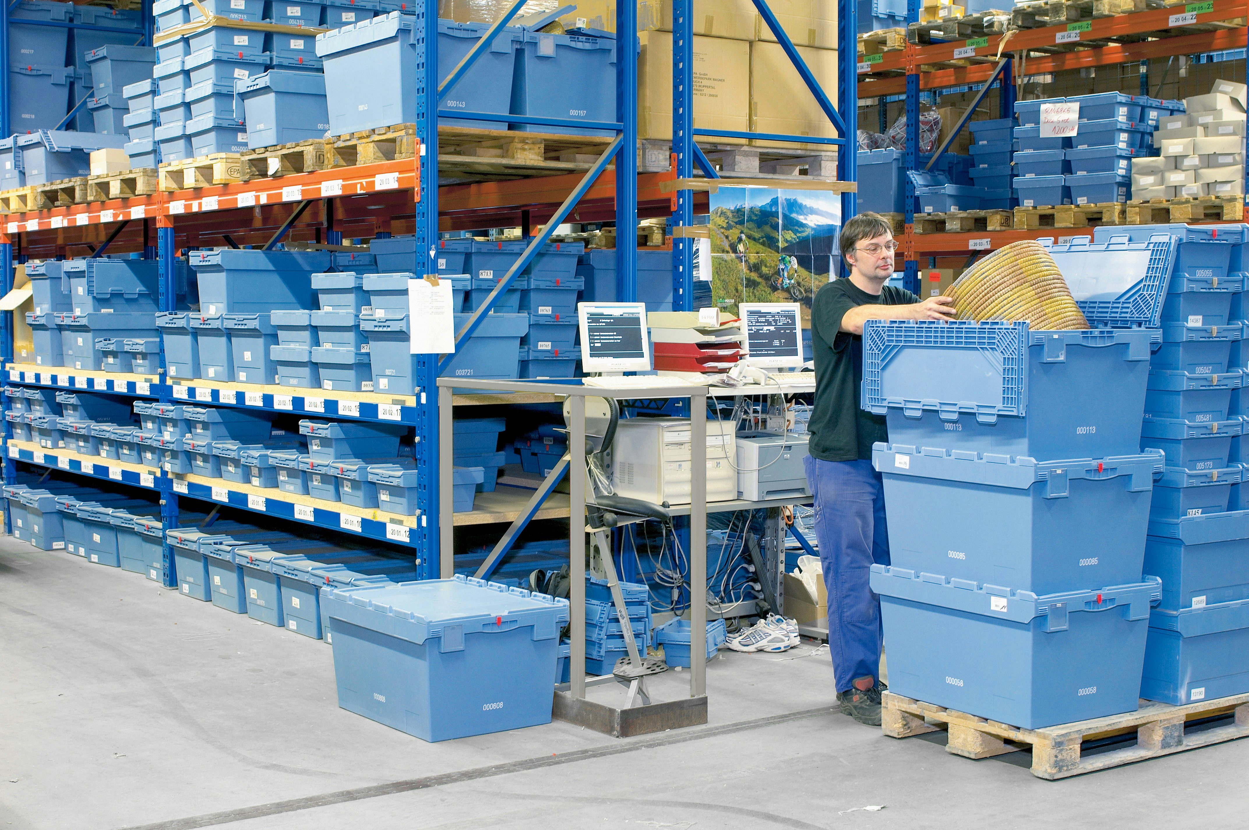 Gestapelte Mehrwegbehälter MB vor und in einem Palettenregal