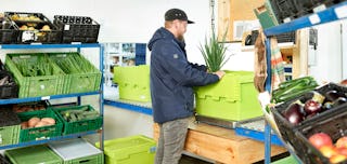 Arbeiter verpackt Lebensmittel Mehrwegbehälter MB Food