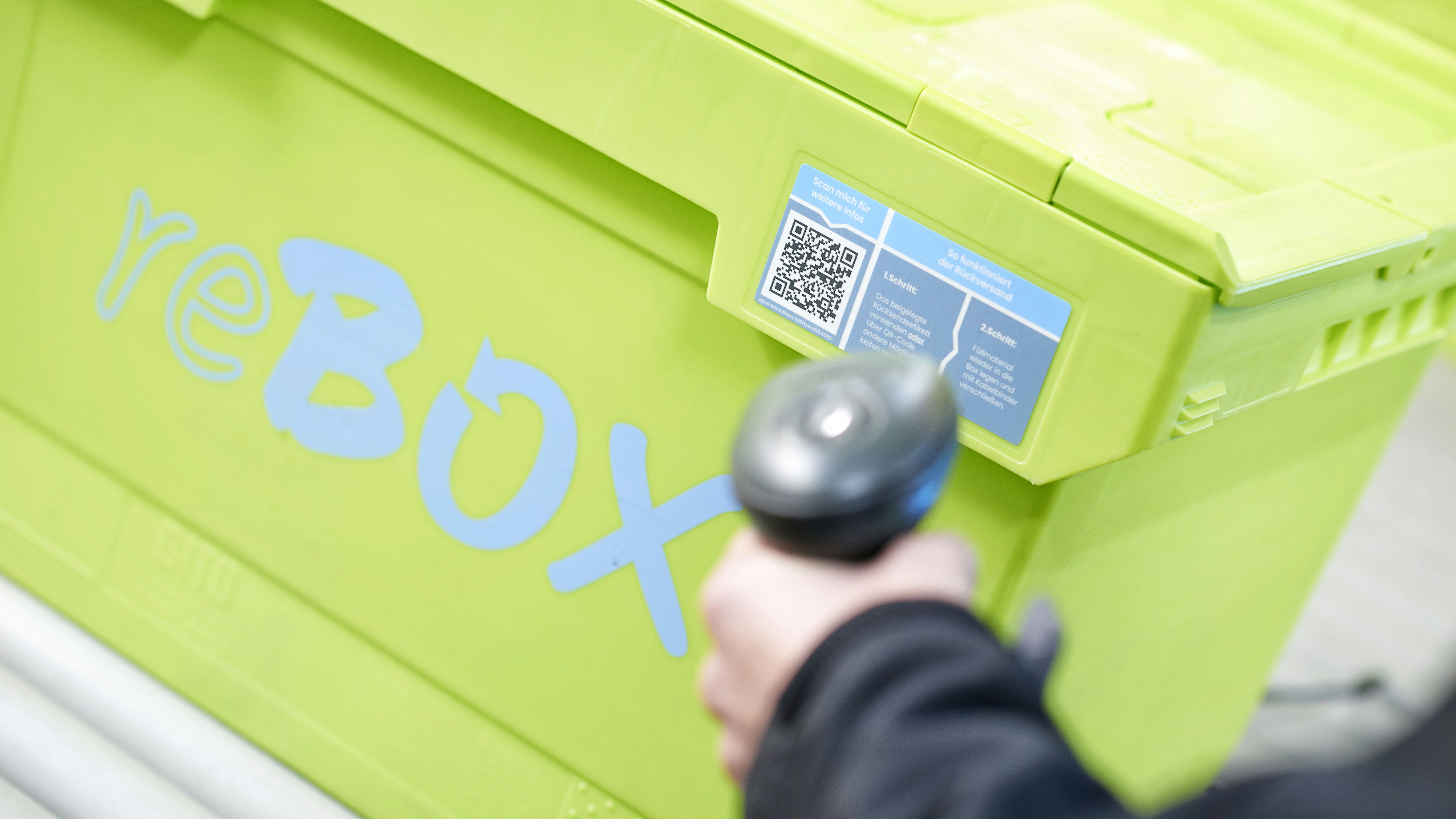 Mitarbeiter Scannt einen QR Code an einem MB Food Behälter