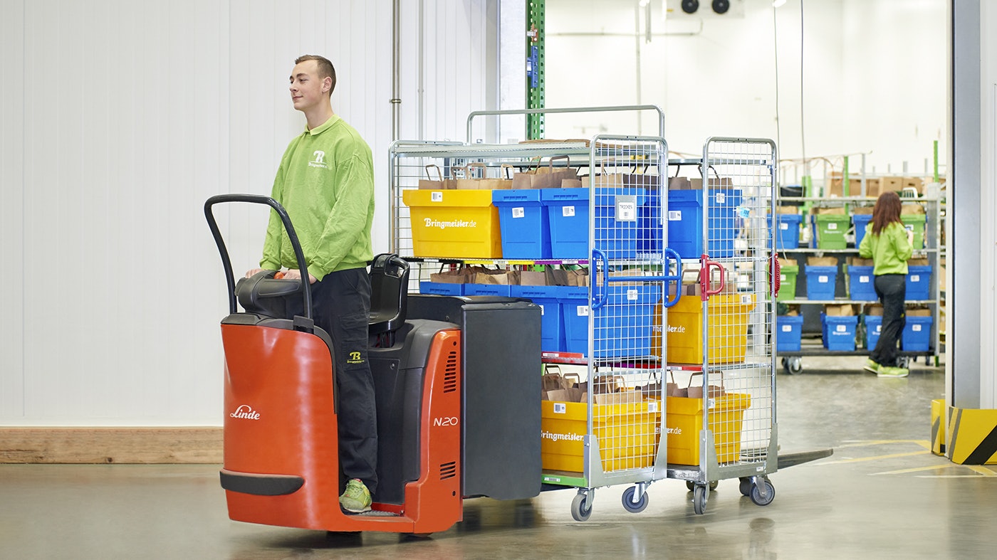 Ein Mann auf einem Flurförderzeug, beladen mit MB Food Behältern