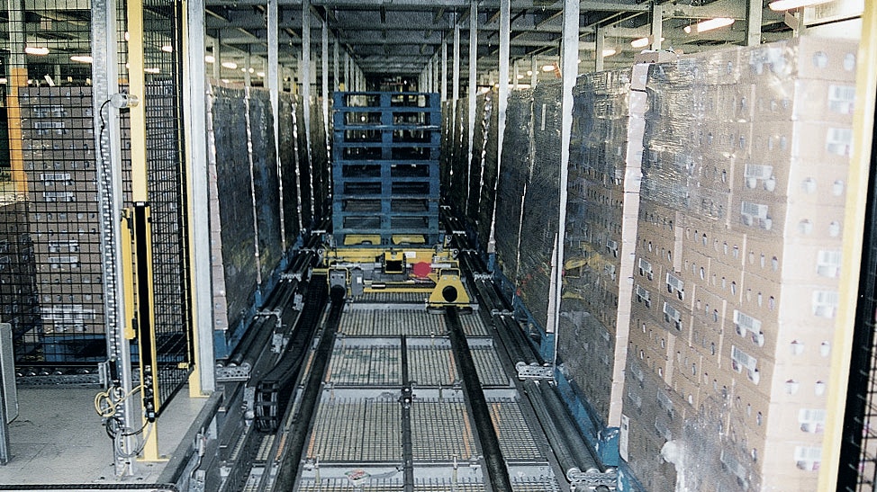 Ein Shuttle, beladen mit leeren Paletten, auf dem Weg durch das automatisierte Lager