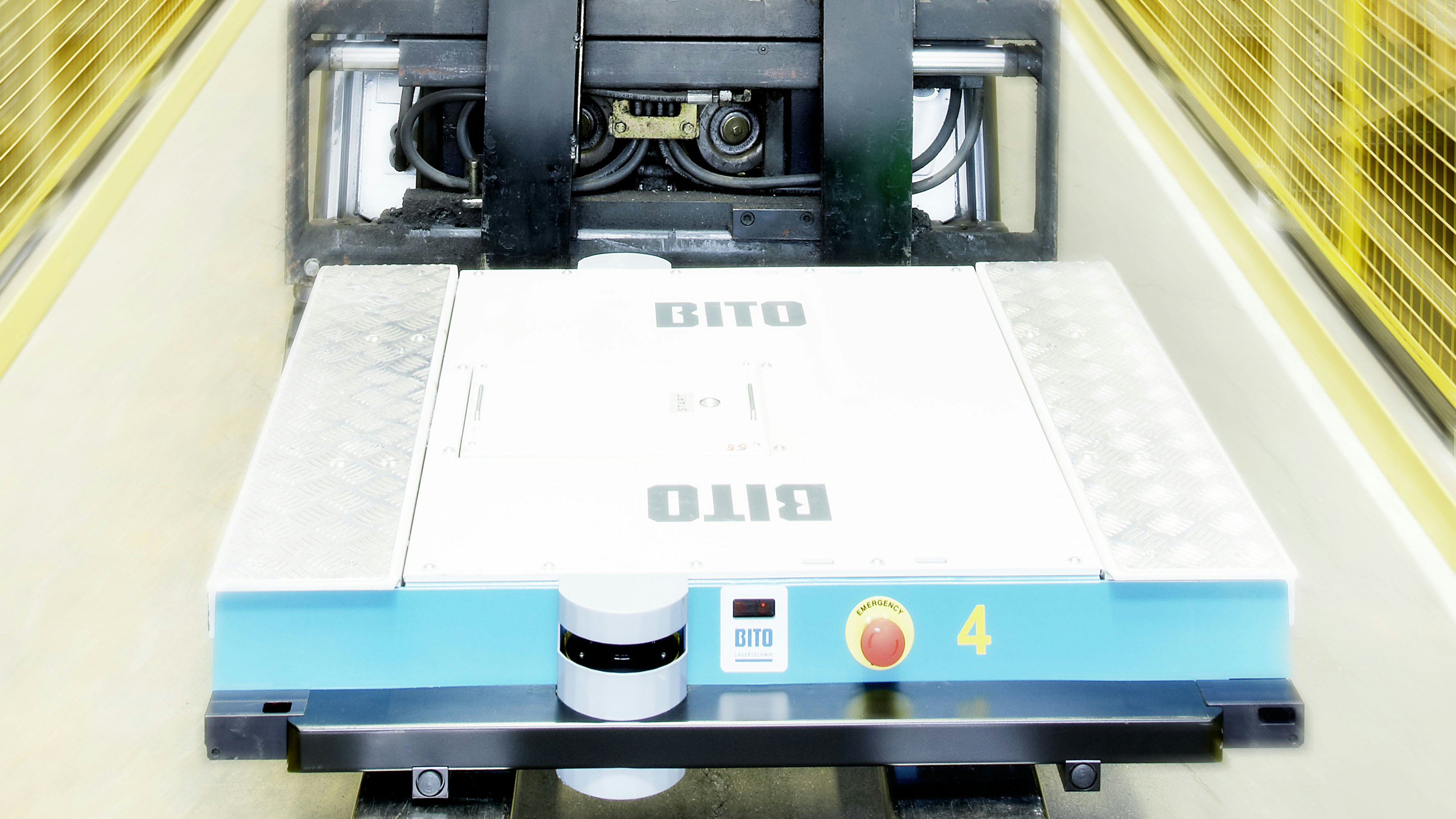 Ein Mitarbeiter auf einem Flurförderzeug befördert ein BITO Regalshuttle an seinem Einsatzort