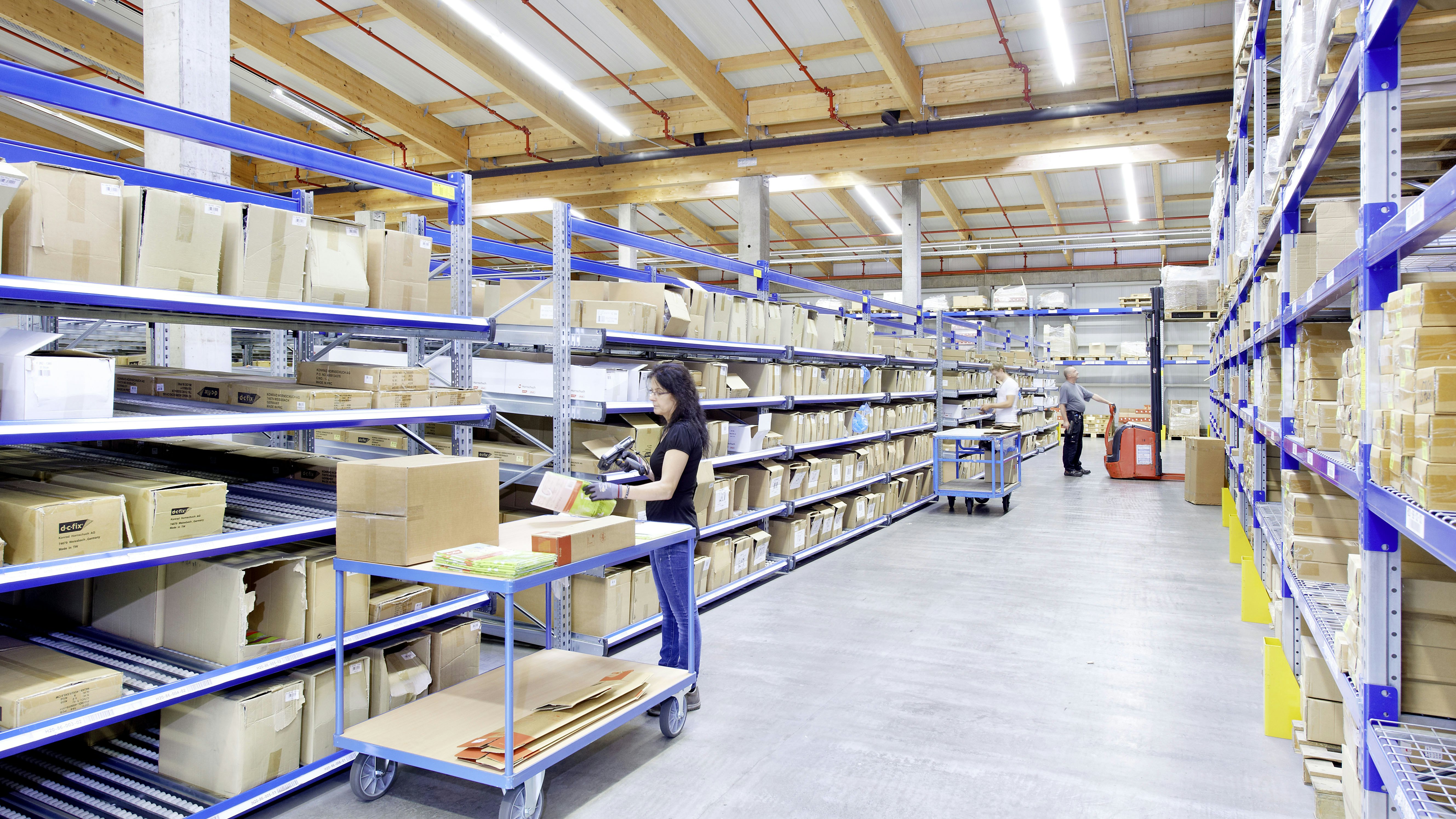 Mehrere Mitarbeiter bei ihrer Arbeit in einem Regallager