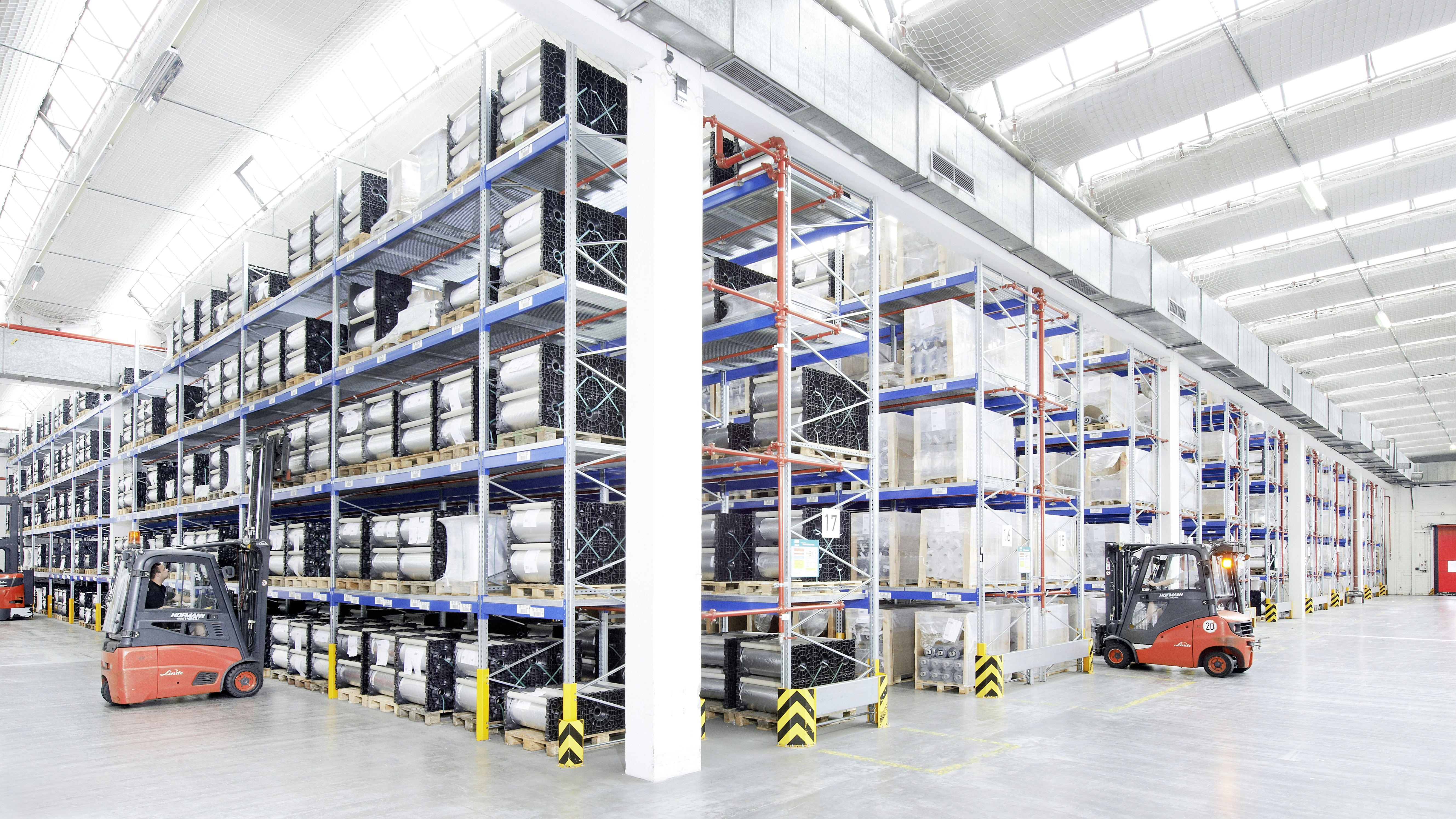 Mehrere Mitarbeiter bei ihrer Arbeit in einem Palettenregal