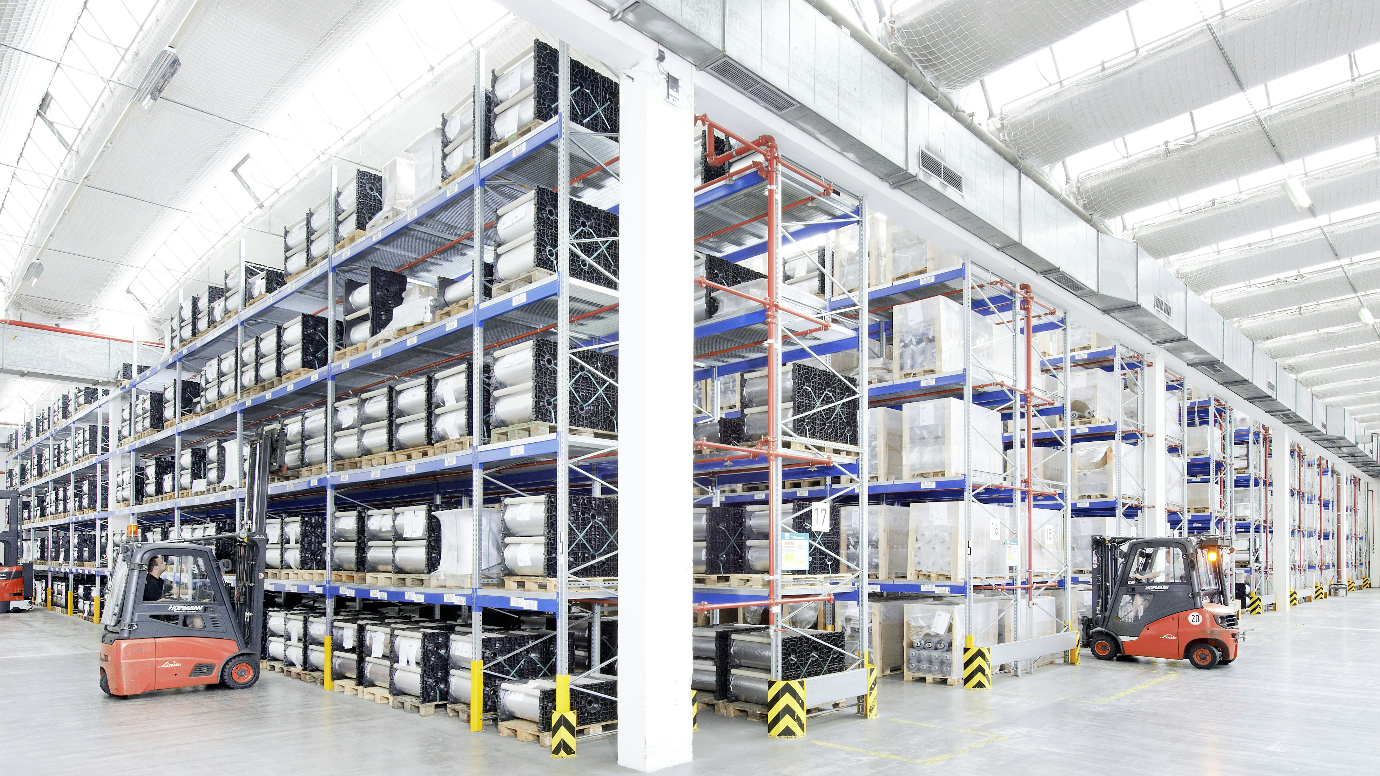 Mehrere Mitarbeiter bei ihrer Arbeit in einem Palettenregal