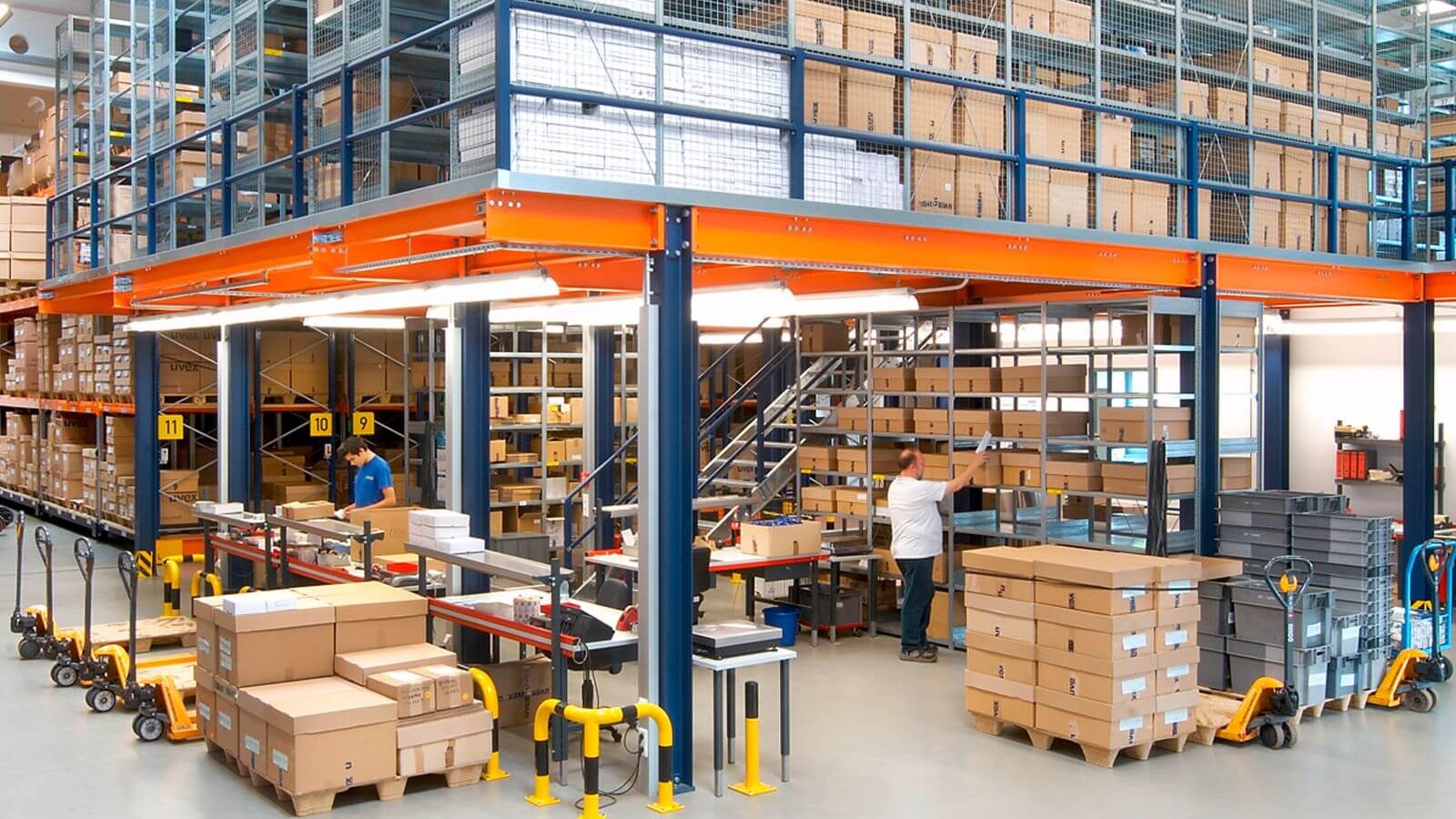 Mehrere Mitarbeiter bei ihrer Arbeit in einem Lagerbühnensystem