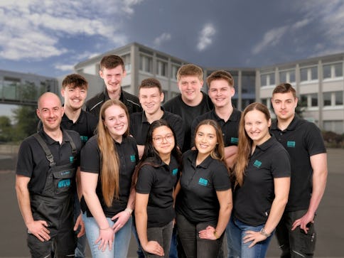 Viele Personen in BITO Kleidung vor dem BITO Verwaltungsgebäude