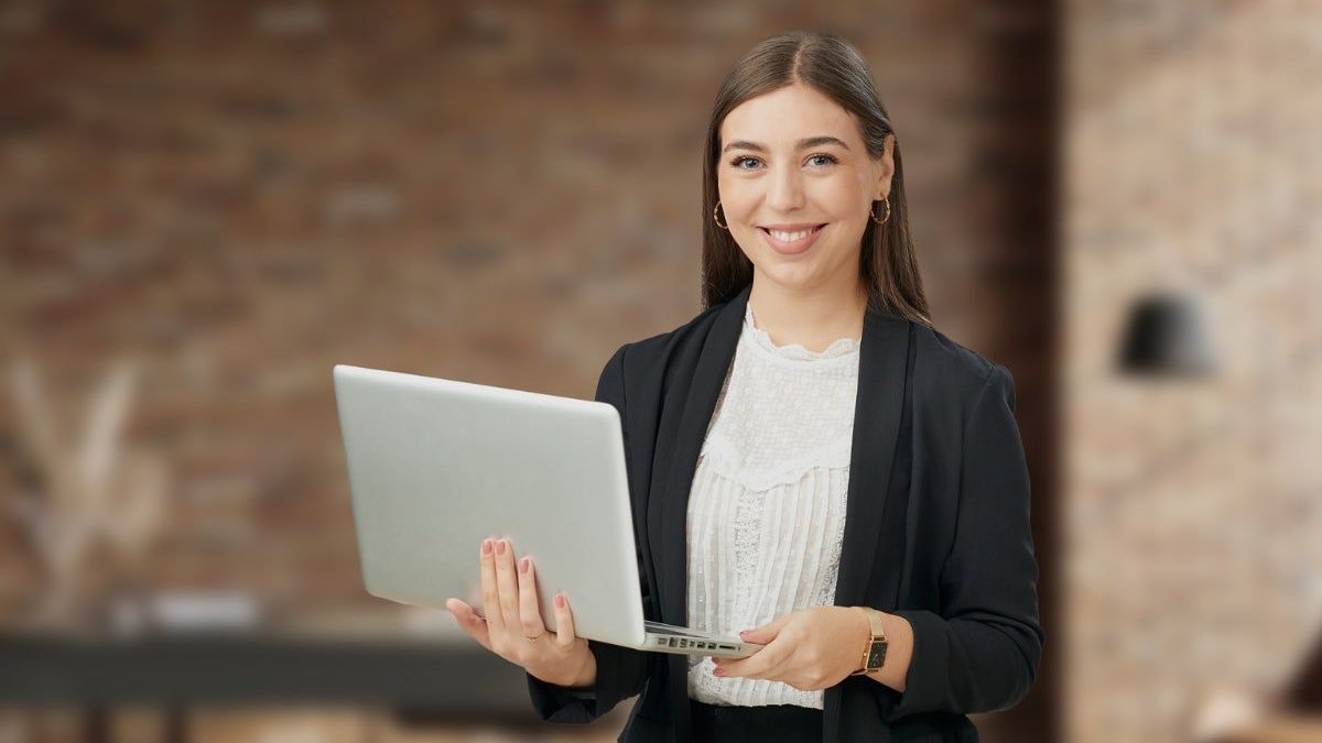 Eine Frau mit einem aufgeklappten Laptop in der Hand