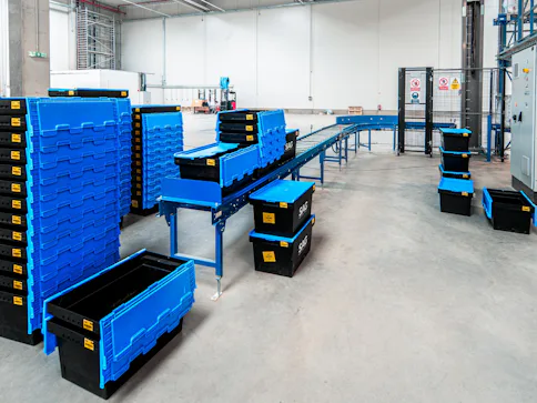 Blaue und schwarze Kunststoffbehälter in Lagerumgebung